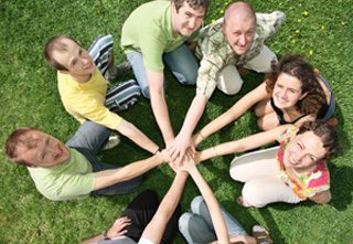 group of people with hands in center of circle