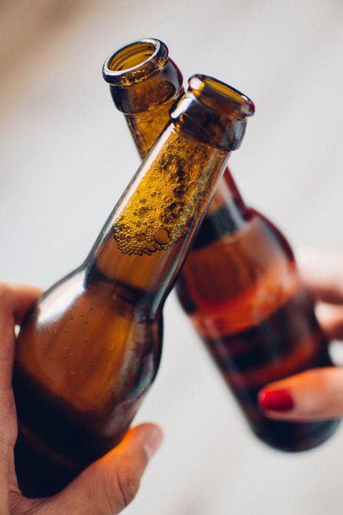 two beer bottles being toasted