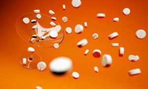 pills falling into martini glass