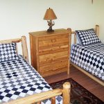 two twin beds with blue and white comforters inside client condo - English Mountain Recovery
