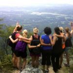 women on hike with arms around each other - English Mountain Recovery