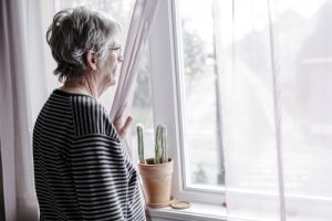 senior woman looking out the window - senior citizens