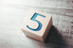 wooden block with the number five painted in blue - myths