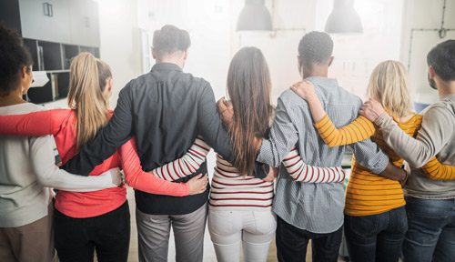 group of people with arms around each other - viewed from behind - 12-Step