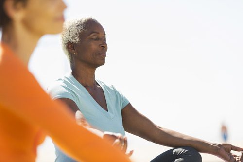 senior age Black woman meditating in the lotus position - styles of meditation